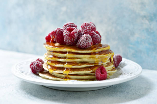 istock Stack of delicious homemade pancakes with maple syrup and fresh raspberry 1167427693
