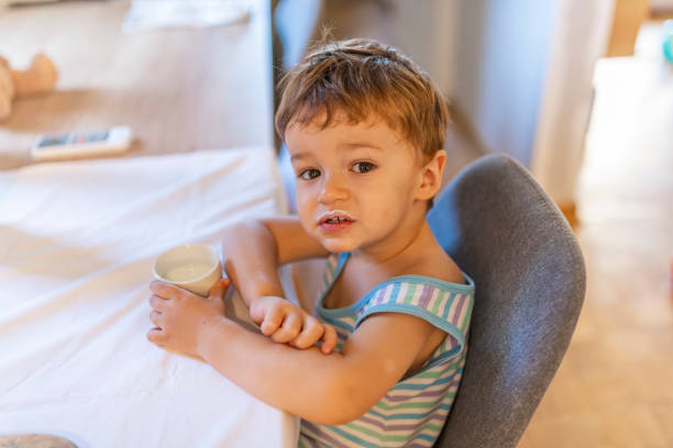 istock Cute little boy eating yogurt. 1167429597