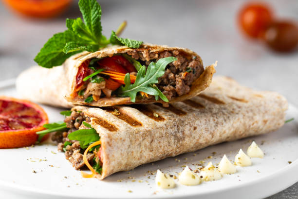 tortilla avvolge panini con verdure fresche, carne macinata e arance rosse sul piatto. burrito, impacchi sandwich, impacchi di fajita - wrap sandwich foto e immagini stock