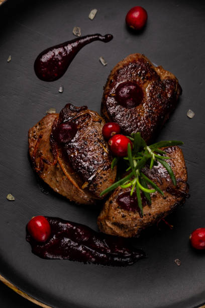 venison or deer steak with ingredients like sea salt, rosemary and cranberry on black plate. food background for restaurant. top view - 7585 imagens e fotografias de stock