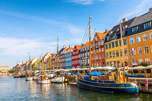 Copenhagen, Denmark - July, 2019: Copenhagen iconic view. Famous old Nyhavn port with colorful medieval houses in the center of Copenhagen, Denmark during summer sunny day.