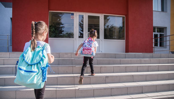 istock Back to school education concept with girl kids, elementary students, carrying backpacks going to class 1167432189
