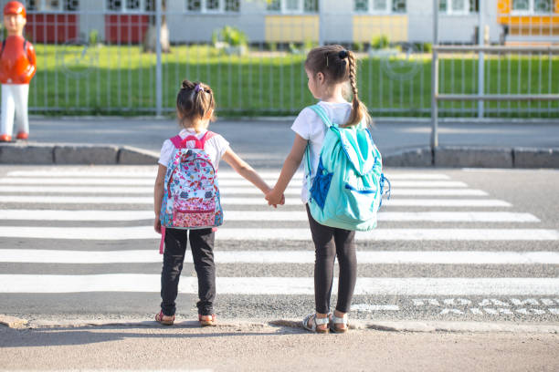 istock Back to school education concept with girl kids, elementary students, carrying backpacks going to class 1167432828