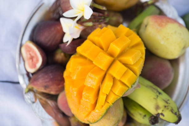 A plate of assorted fruits, sliced mango. The view from the top .