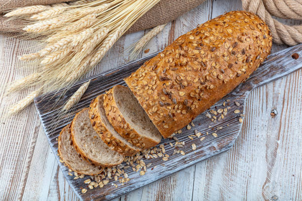 brot, traditionelles sauerteigbrot in scheiben geschnitten auf einem rustikalen holzhintergrund, nahaufnahme, ansicht von oben, kopierraum. konzept der traditionellen gesäuerten brotbackmethoden. - wheat whole wheat close up corn on the cob stock-fotos und bilder