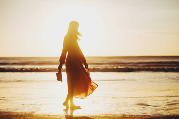 istock young slim beautiful woman on sunset beach 1167435727