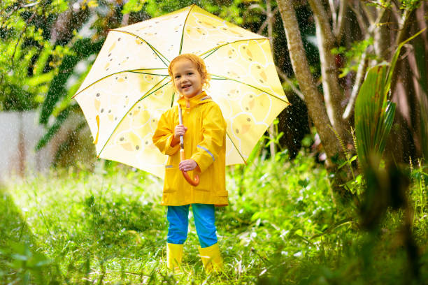 istock Child playing in the rain. Kid with umbrella. 1167436182
