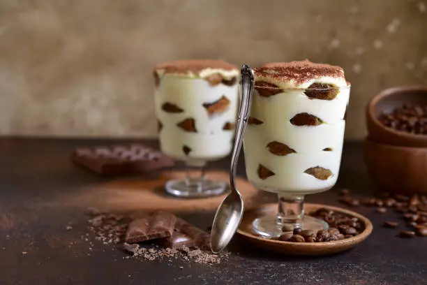 Tiramisu - traditional italian dessert with mascarpone cheese, bisquit, coffee, cream and eggs in a glass.Vintage style.