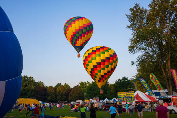 Hot air balloons take to flight at 35th annual Spiedie Fest and Balloon Rally Expo, Inc. Festival goers watch hot air balloons take to flight early Saturday morning, August 3, 2019 on the second day of the 35th annual Spiedie Fest and Balloon Rally Expo, Inc. in Binghamton, New York, USA. binghamton ny stock pictures, royalty-free photos & images