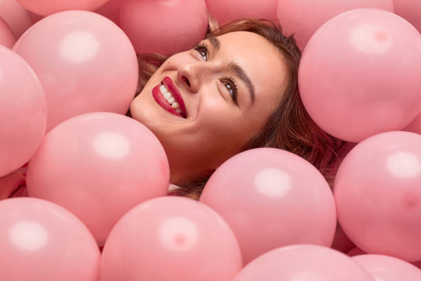 istock Cheerful woman lying in balloons 1167454920