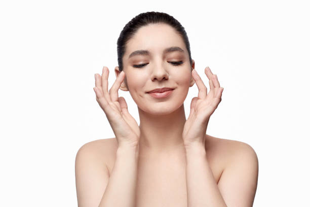 istock Pleased woman smearing cream on cheeks 1167455018