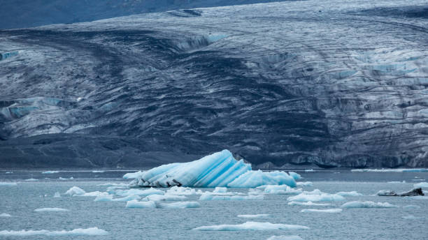 アラスカのプリンスウィリアムサウンドで暗いモレーンの前にストライプの氷山が氷河を覆いました。 - glacier alaska iceberg melting ストックフォトと画像
