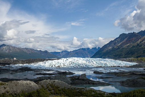 View of the Matanuska Glacier in 2019 with a large lake in front of the icefall of the glacier.