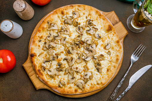 pizza with mushrooms on dark rustic background