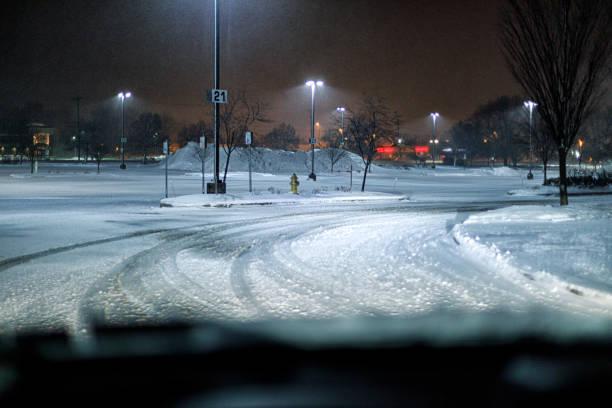 slippery parking lot curve during winter night blizzard snow storm - street light parking lot night lot imagens e fotografias de stock