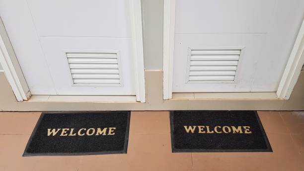 istock Two doormats lying in front of two doors with welcome written on it 1167471357
