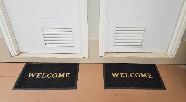 istock Two doormats lying in front of two doors with welcome written on it 1167471366