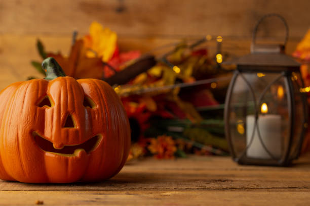 istock Halloween pumpkin head jack lantern on a wooden background with blurry lights, background for the holiday 1167471411