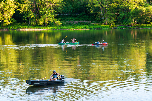 Althom, Pennsylvania, USA 8/10/2019 A boat and kayaks on the Allegheny river in Warren county on a summer day