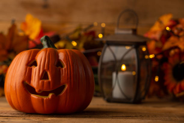 istock Halloween pumpkin head jack lantern on a wooden background with blurry lights, background for the holiday 1167472414