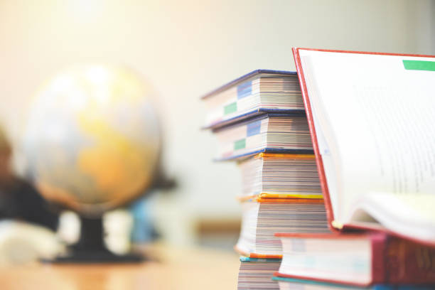 istock Education concept back to school and business study global world - open book in library with book stacked and earth globe model map 1167474014