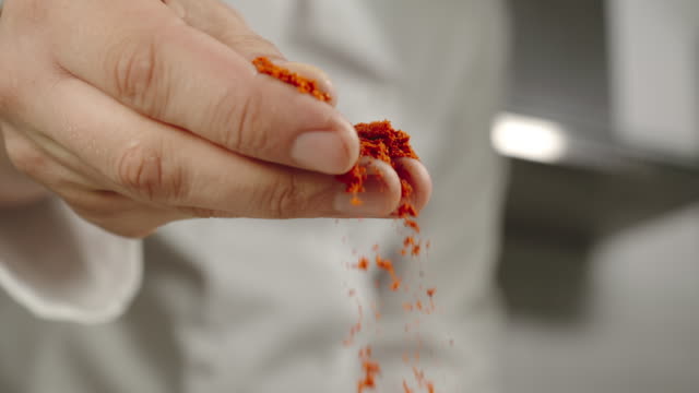 SLOW MOTION: Chef Sprinkles Red Pepper Powder While Cooking