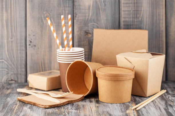 Craft paper tableware Eco craft paper tableware. Paper cups, dishes, bag, fast food containers and  wooden cutlery on wooden background. Recycling concept. Copy space biodegradable photos stock pictures, royalty-free photos & images
