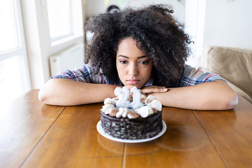 Young african woman holding birthday cake.