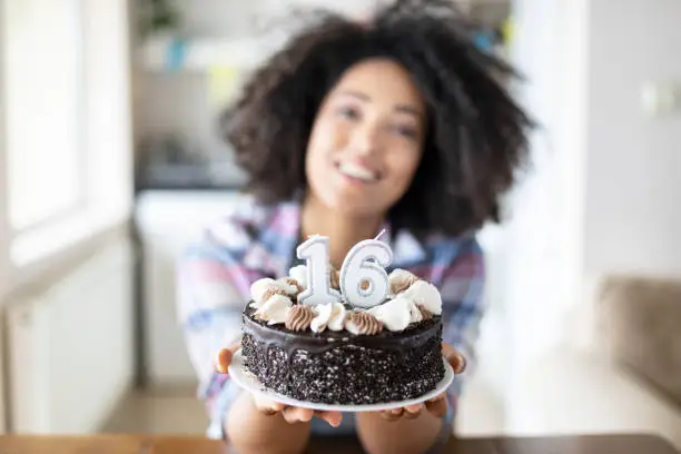 Photo of Smiling woman holding birthday cake with candles