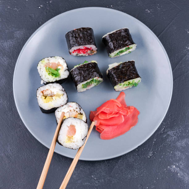 istock Sushi roll with chopsticks large on a plate background with rolls top view 1167489929