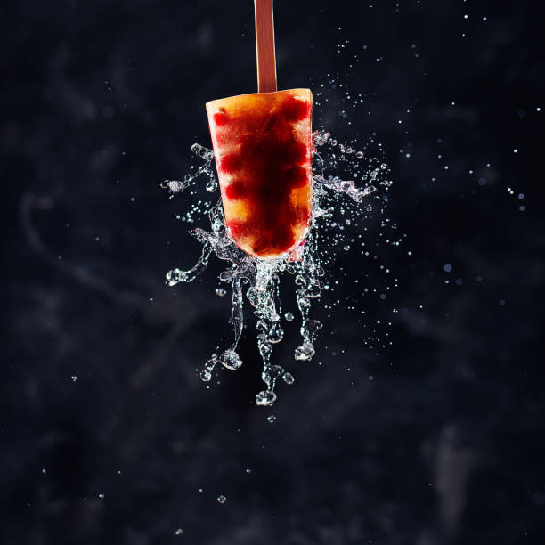 Home-made ice lollies made from berries with splashing water