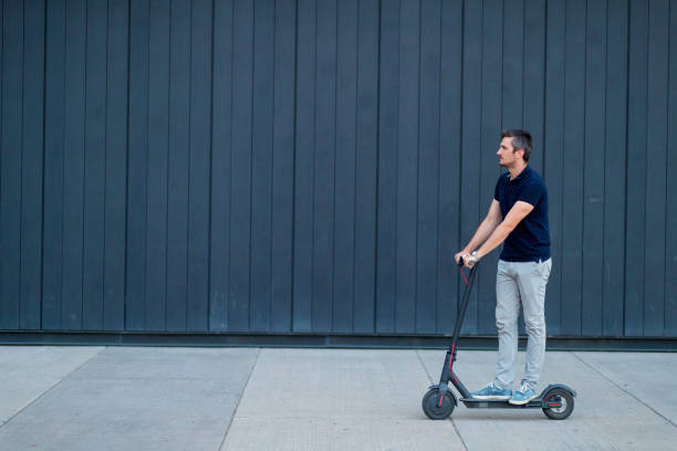 istock Commuter riding electric push scooter by the wall 1167494482