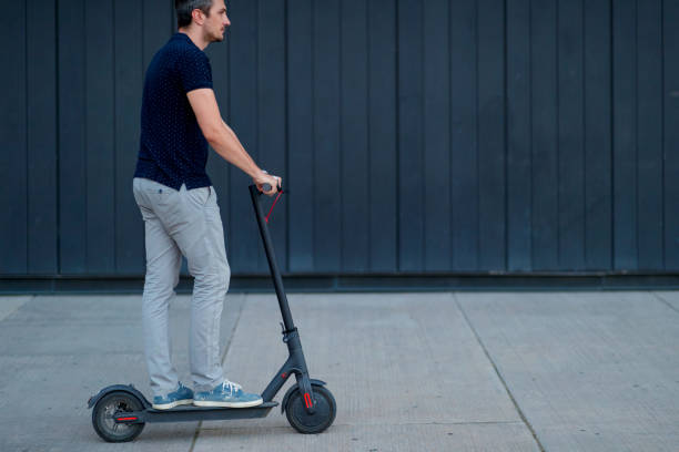 istock Commuter riding e-scooter down the patio by the wall 1167494484