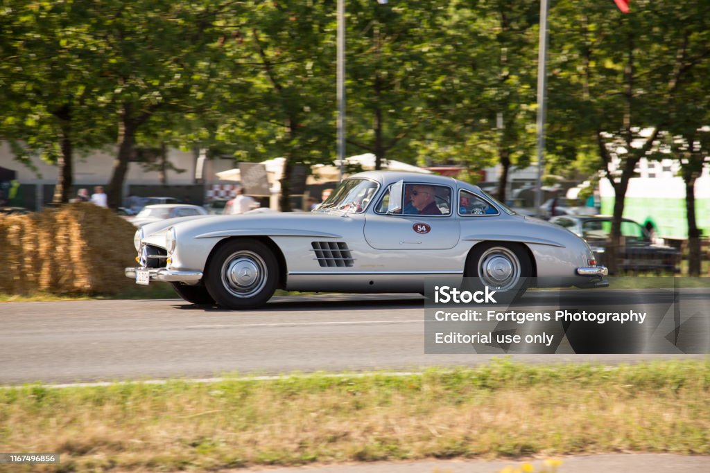A Silver Grey Mercedesbenz 300sl Gullwing Racing On The Tracks