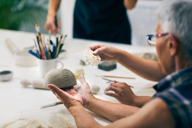 Senior woman making bowl on ceramics workshop