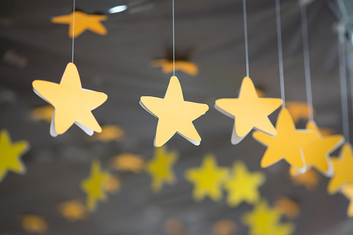 Yellow star hanging mobile with black background.Handmade paper star hanging mobile.