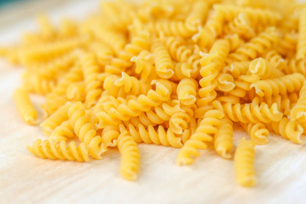 fusilli na drewnianym stole. fusilli jest rodzajem spaghetti. - short paste zdjęcia i obrazy z banku zdjęć