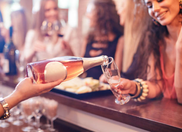 젊은 여성에게 장미 와인 한 잔을 붓는 바텐더의 손 - 5601 뉴스 사진 이미지