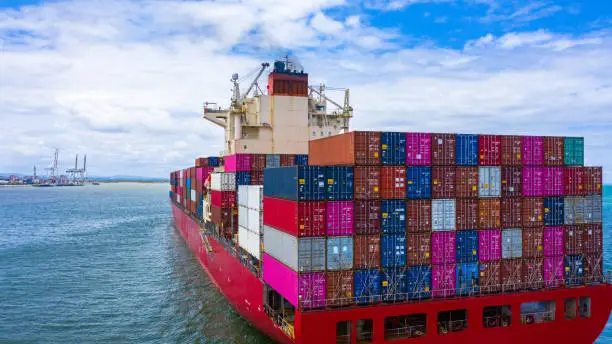 Container cargo ship carrying container for business freight import and export, Aerial view container ship arriving in commercial port.