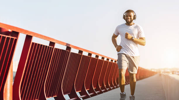 istock Cheerful african american man running along the bridge 1167503075