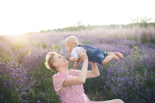 istock Happy mother with little son playing on lavender field 1167503418