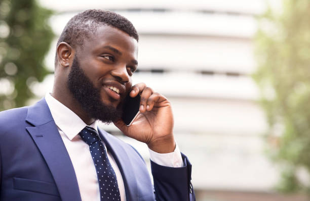 istock Bearded African American businessman talking on cell phone with customer 1167504654