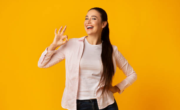 istock Excited Girl Gesturing OK Sign On Yellow Studio Background 1167504700