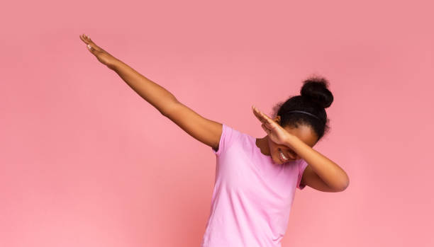Teen girl throwing dab move standing against pink background Teen girl throwing dab move standing against pink background, panorama with copy space dab dance photos stock pictures, royalty-free photos & images