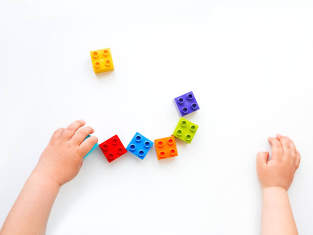 istock Child is playing with colorful constructor blocks. Kid's hands with bricks toy on white background. Educational toy, flat lay, top view. 1167505750