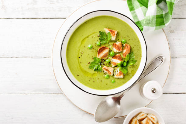 гороховый суп. зеленый гороховый суп из пюре в миске, подается с тостами на гриле, вид сверху - vegan pea soup стоковые фото и изображения