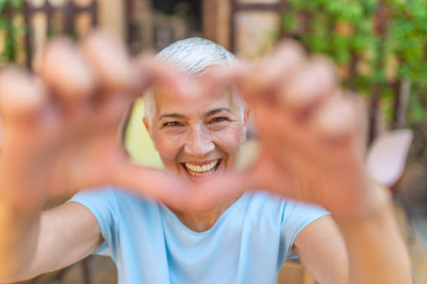 istock Cute senior old woman making a heart shape 1167510275