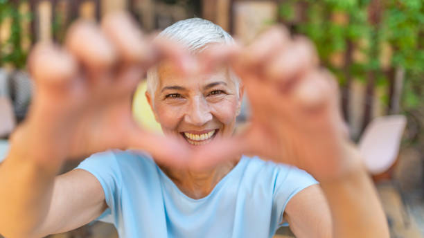 istock Cute senior old woman making a heart shape 1167510276