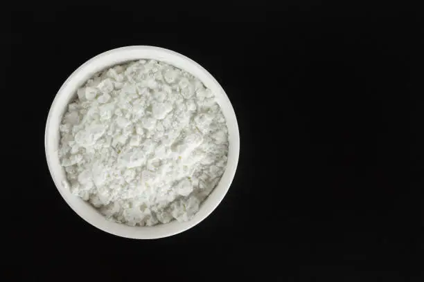 white flour in bowl cooking on black background.