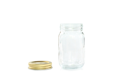 Empty jar of golden cap is open on a white background.